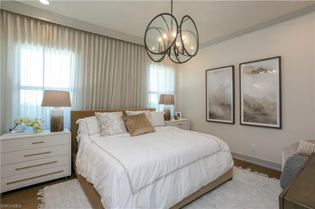 a bedroom with bed and a chandelier