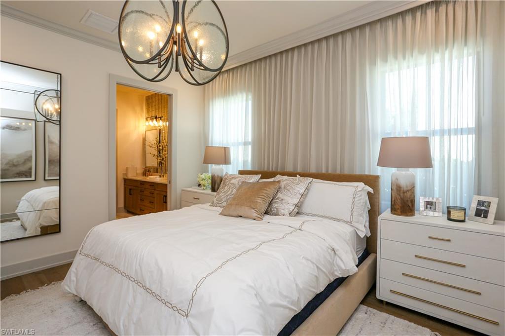 14727 Kingfisher Loop Naples, FL 34120 - Photo 20 of 50 a bedroom with a bed and a chandelier