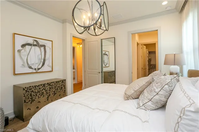 a bedroom with a bed and a chandelier