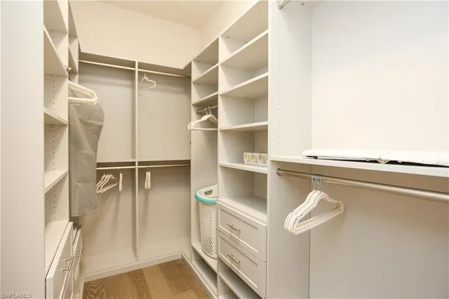 a view of walk in closet with empty racks