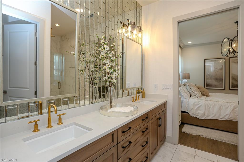 14727 Kingfisher Loop Naples, FL 34120 - Photo 25 of 50 a bathroom with double vanity sinks and a mirror