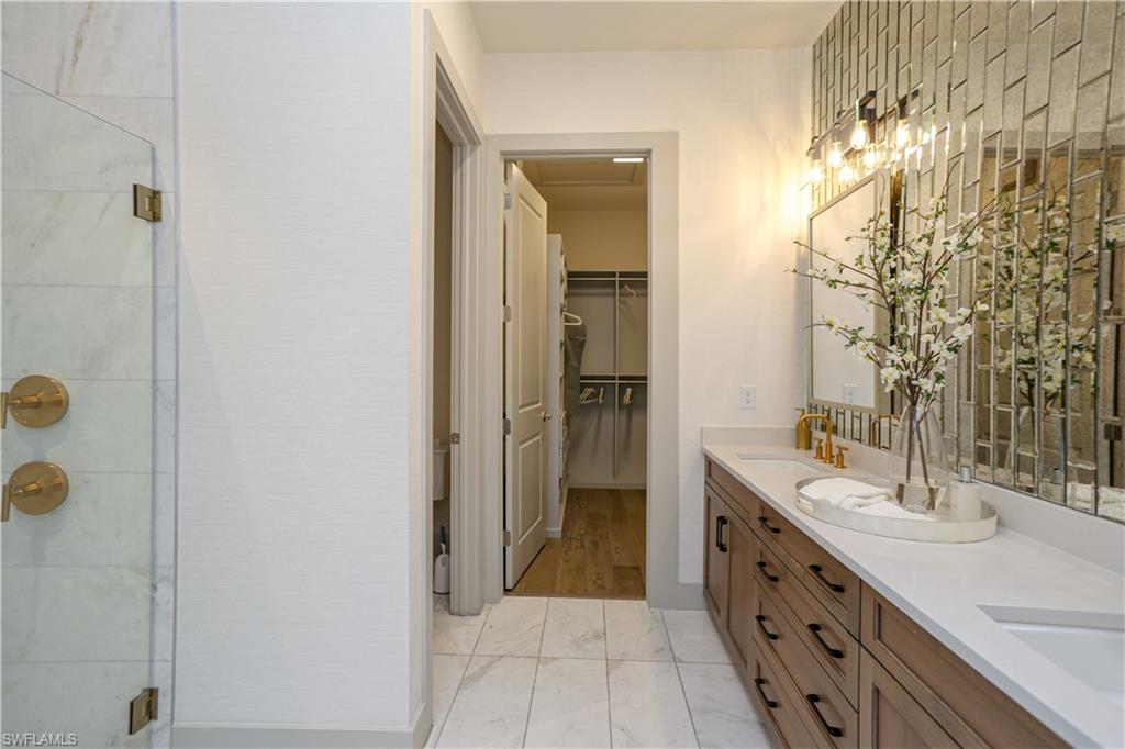 14727 Kingfisher Loop Naples, FL 34120 - Photo 26 of 50 a bathroom with a double vanity sink mirror and shower
