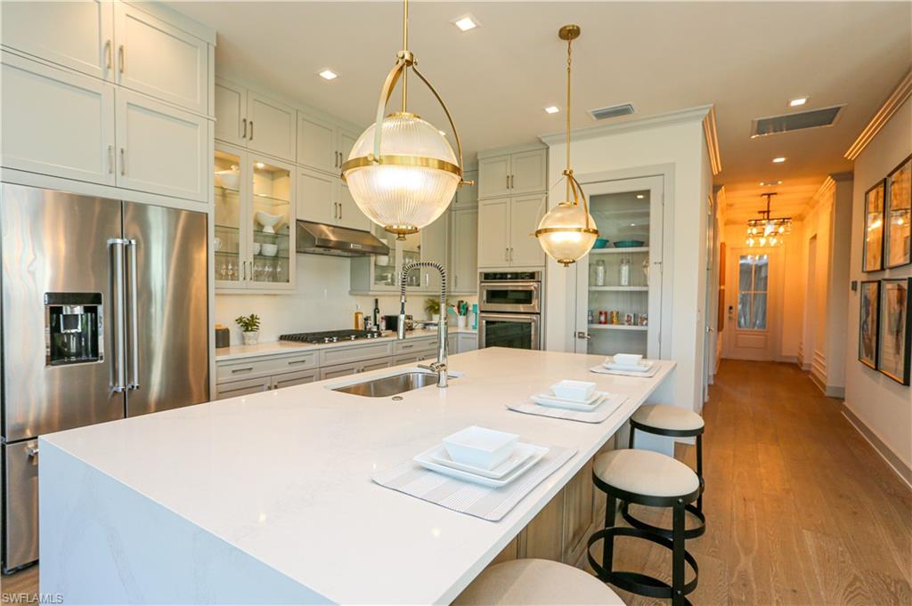 14727 Kingfisher Loop Naples, FL 34120 - Photo 32 of 50 a kitchen with sink and refrigerator