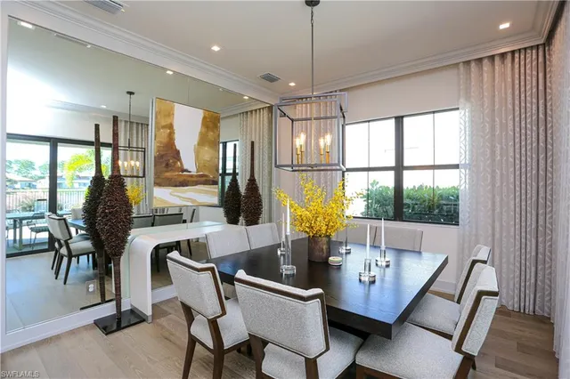 a view of a dining room with furniture a chandelier and wooden floor