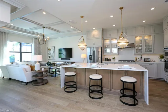 a kitchen with a dining table chairs sink and white cabinets