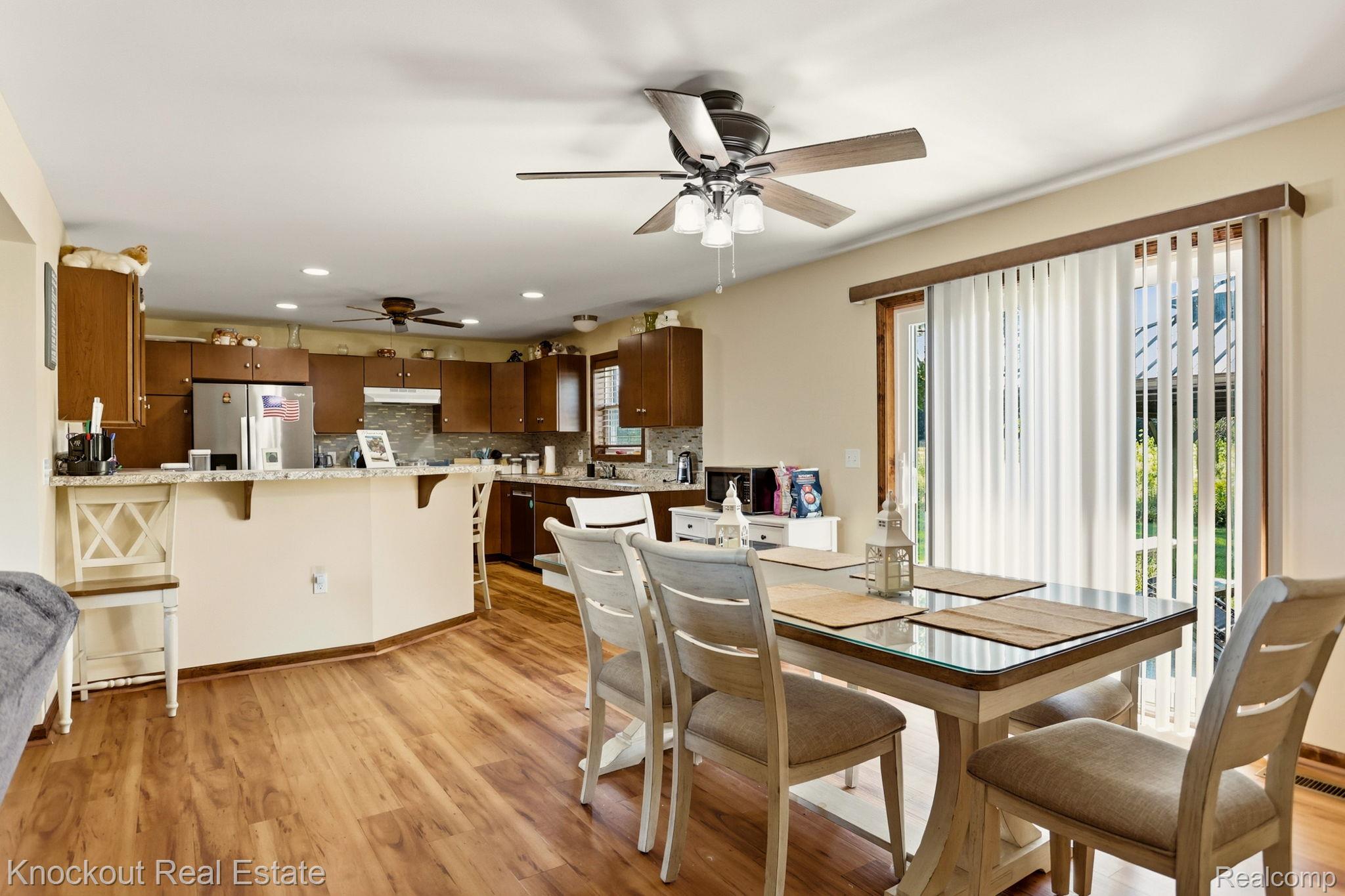 5727 Mackinaw Road Saginaw, MI 48604 - Photo 15 of 60 Wood-finish flooring throughout, kitchen with wood cabinetry and light-colored countertops, recessed lighting, and ceiling fan with integrated lighting