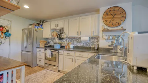 a kitchen with stainless steel appliances granite countertop a sink and a refrigerator