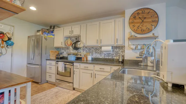 a kitchen with stainless steel appliances granite countertop a sink and a refrigerator