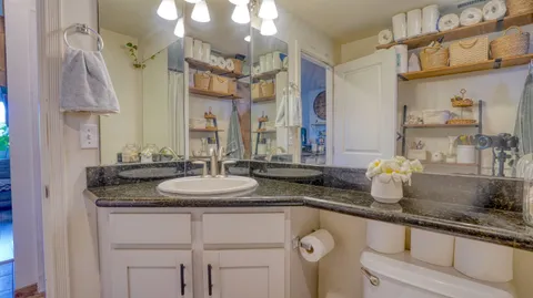 a spacious bathroom with a granite countertop sink a mirror and a shower