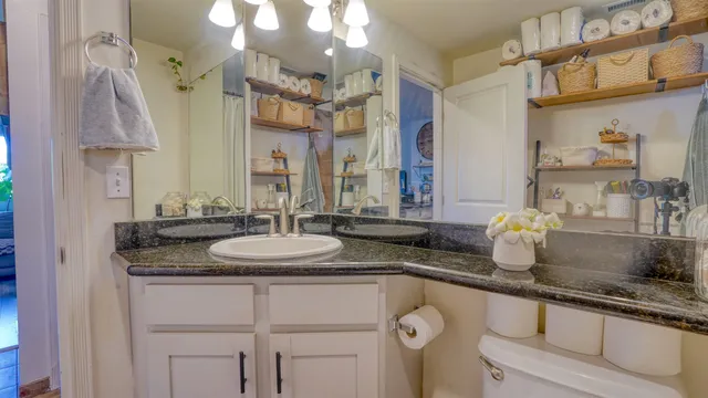 a spacious bathroom with a granite countertop sink a mirror and a shower
