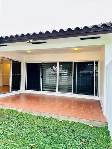 a view of a house with a yard and a large tree