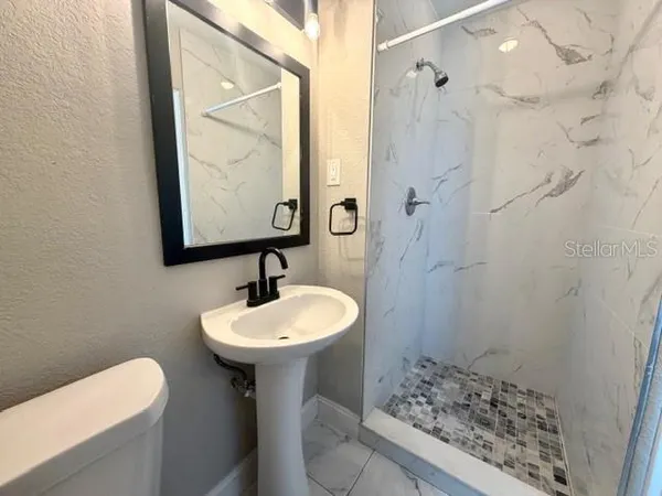 a bathroom with a sink toilet and shower