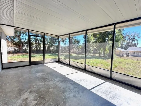 a view of an empty room with wooden floor and a balcony