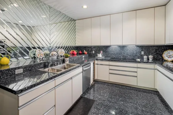a kitchen with stainless steel appliances granite countertop a sink a stove and cabinets
