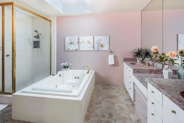 a bathroom with a granite countertop sink a mirror and a bathtub