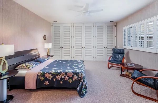 a bedroom with a bed chair and a large window