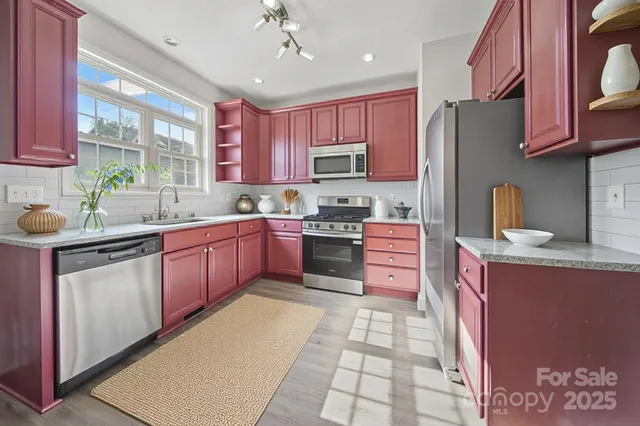 a kitchen with kitchen island granite countertop a sink stainless steel appliances and cabinets