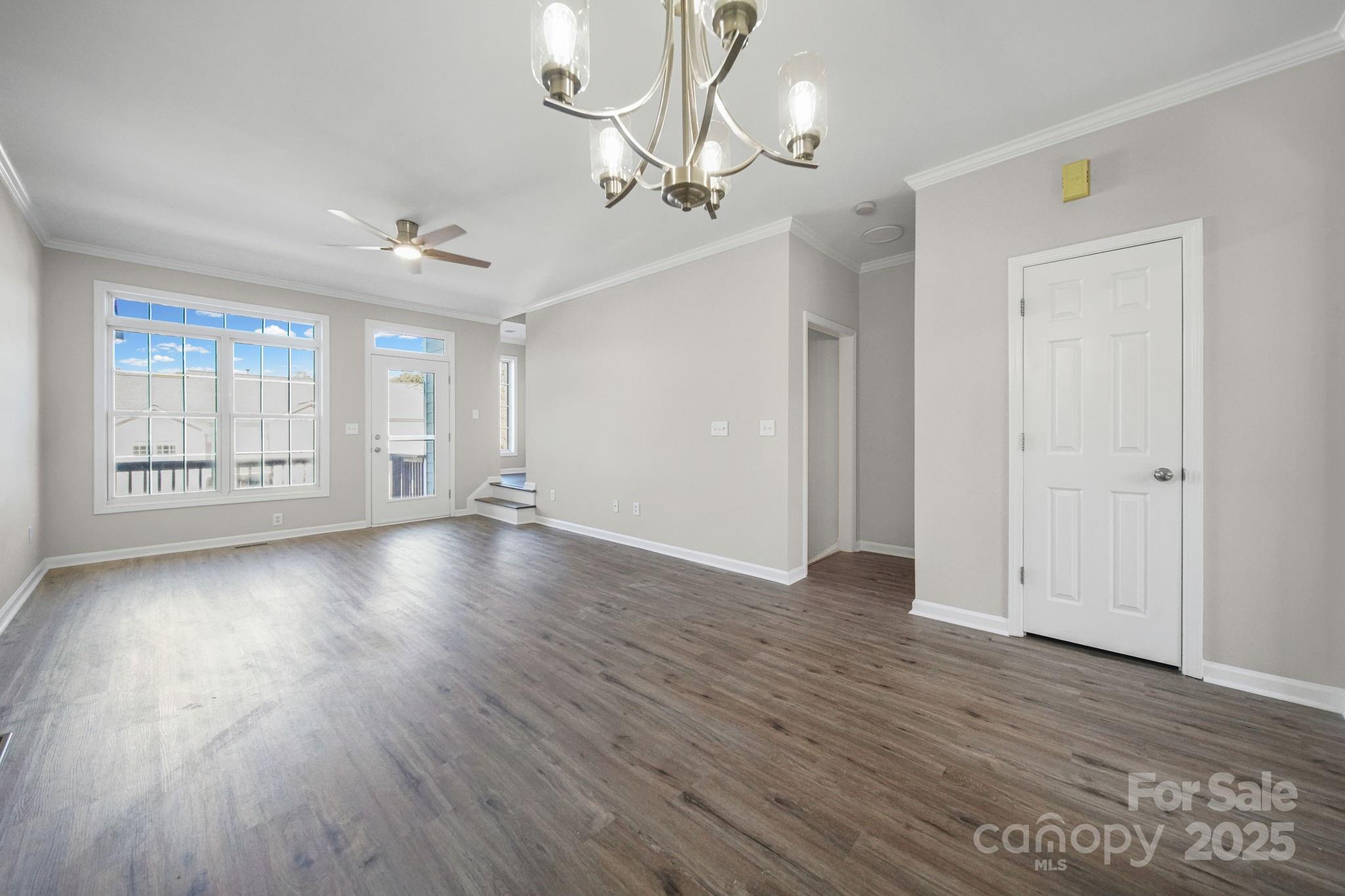 115 Sun Ridge Drive Mooresville, NC 28117 - Photo 11 of 30 an empty room with wooden floor chandelier and windows
