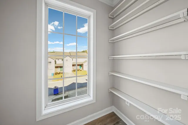 a view of a closet area with wooden floor