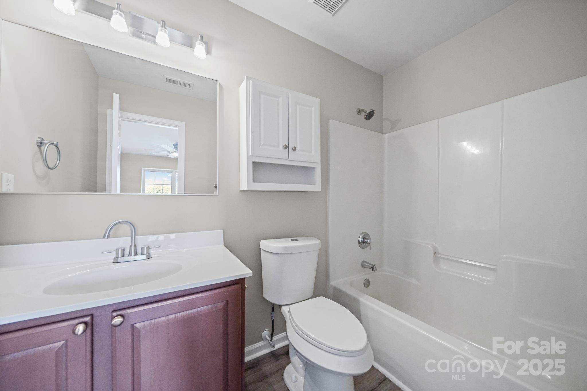 115 Sun Ridge Drive Mooresville, NC 28117 - Photo 26 of 30 a bathroom with a toilet a sink a mirror and a shower