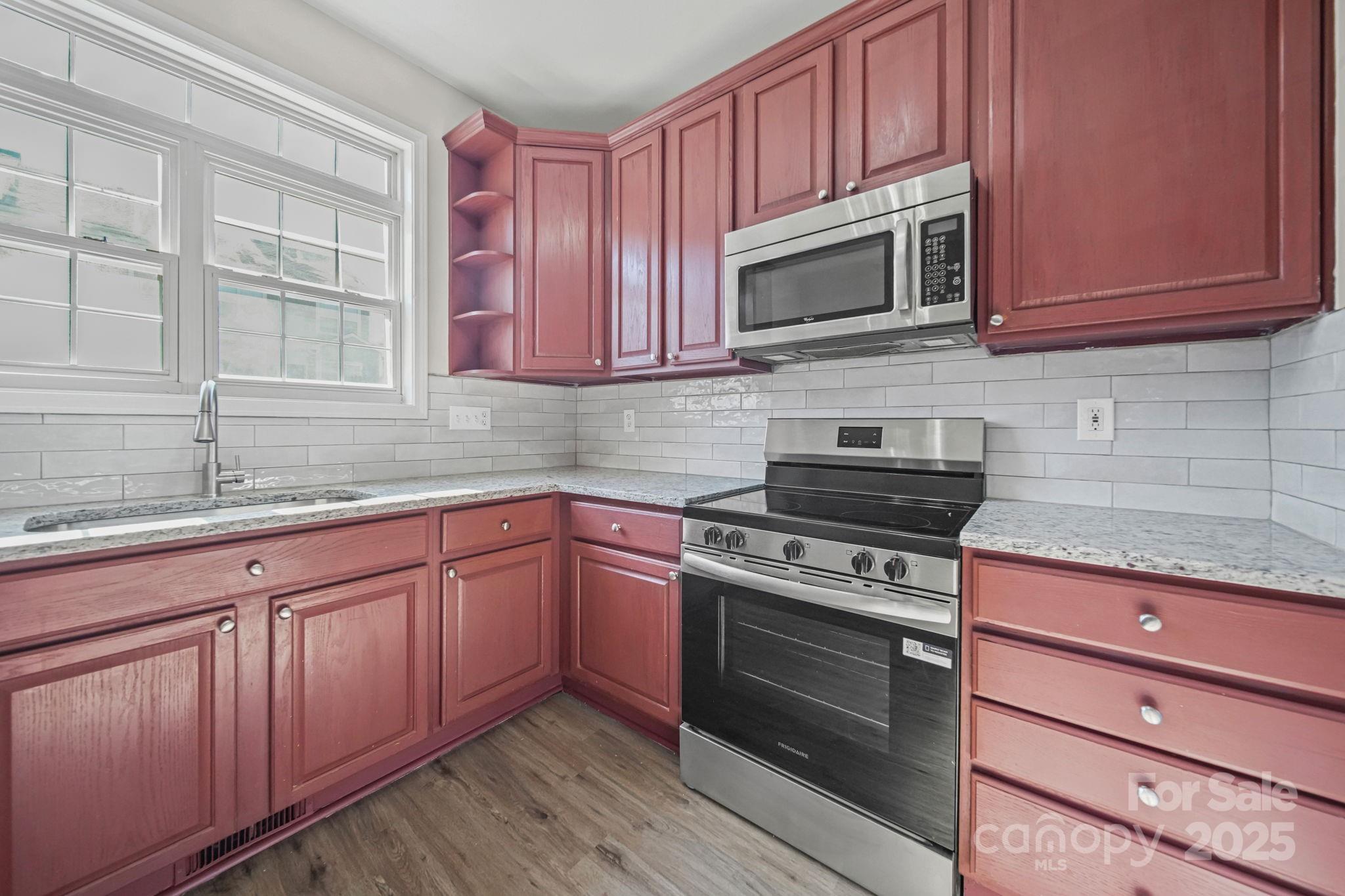 115 Sun Ridge Drive Mooresville, NC 28117 - Photo 4 of 30 a kitchen with wooden cabinets stainless steel appliances and a sink