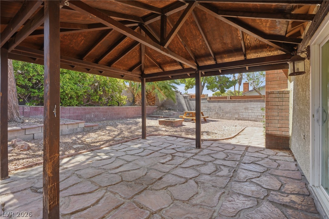 3971 Spring Leaf Drive Las Vegas, NV 89147 - Photo 22 of 48 A private backyard retreat, featuring a covered patio with flagstone-style paving, fire pit, and ample space for outdoor enjoyment.