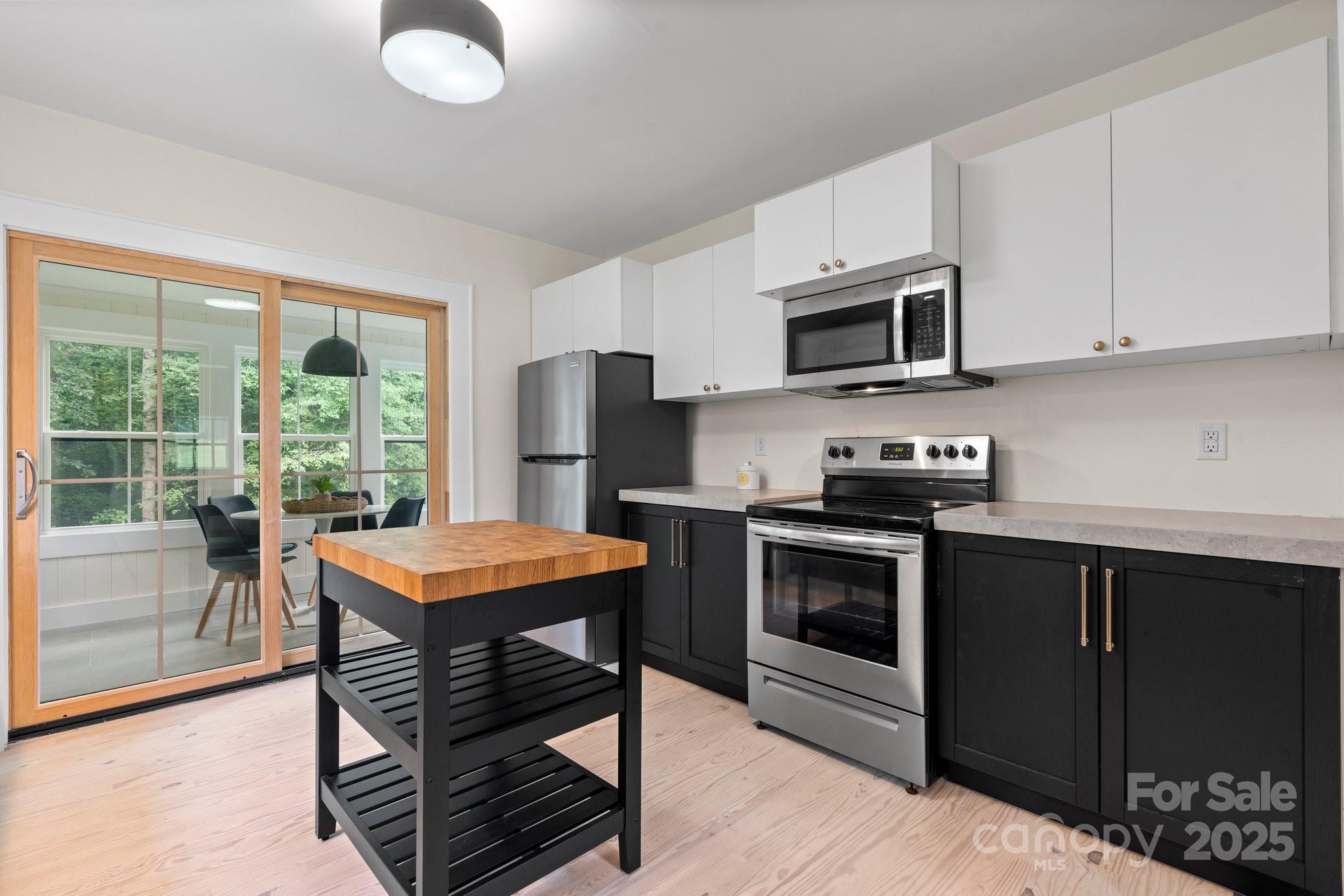 2704 Kool Park Road Northeast Hickory, NC 28601 - Photo 6 of 23 a kitchen with stainless steel appliances kitchen island granite countertop a stove top oven a sink dishwasher a dining table and chairs with wooden floor