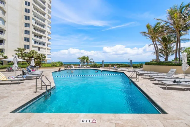 a view of swimming pool with outdoor seating and a garden