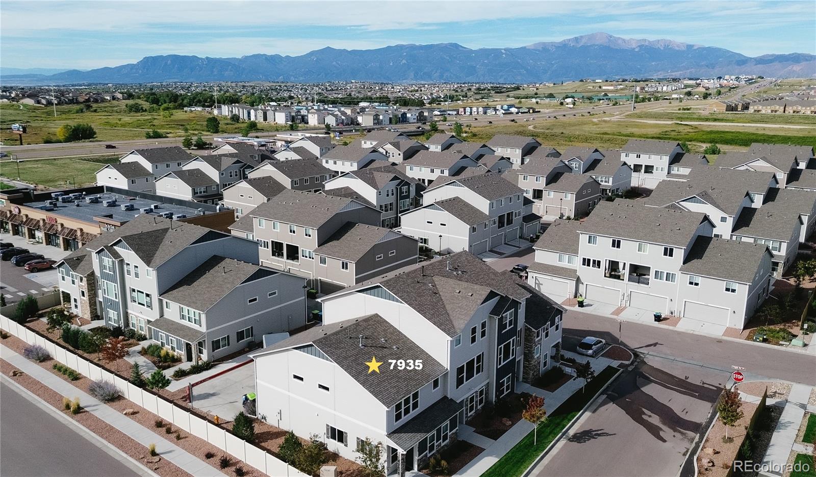 7935 Shilo Mesa Drive Colorado Springs, CO 80908 - Photo 1 of 30 an aerial view of a city with lots of residential buildings and mountain view in back