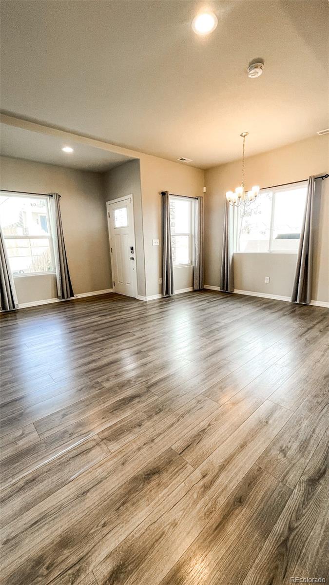 7935 Shilo Mesa Drive Colorado Springs, CO 80908 - Photo 14 of 30 an empty room with wooden floor and windows