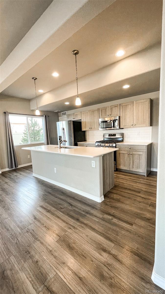 7935 Shilo Mesa Drive Colorado Springs, CO 80908 - Photo 25 of 30 a large kitchen with stainless steel appliances granite countertop a stove and a wooden floors