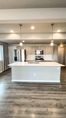 a view of kitchen with stainless steel appliances granite countertop sink stove and cabinets