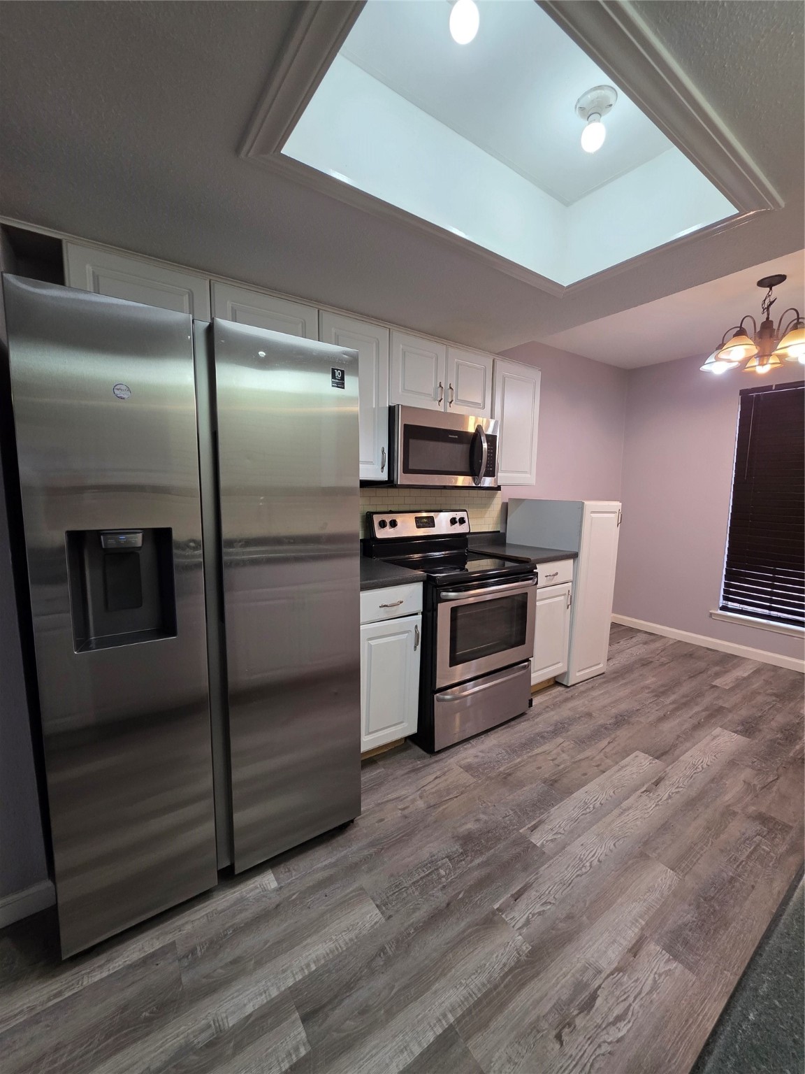 9611 Jaywood Street Houston, TX 77040 - Photo 5 of 22 a kitchen with a refrigerator stainless steel appliances wooden floor and cabinets