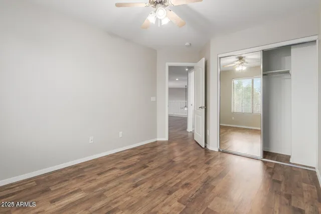 an empty room with wooden floor and mirror