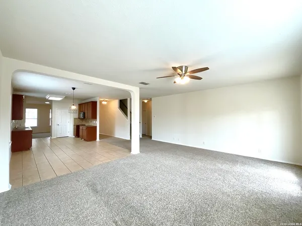 an empty room with a kitchen and entryway
