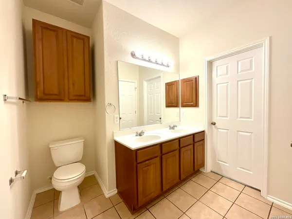 a spacious bathroom with a toilet sink and mirror