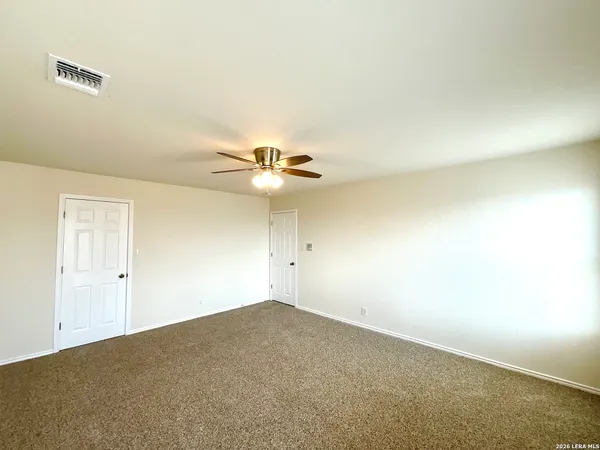 an empty room with a chandelier fan