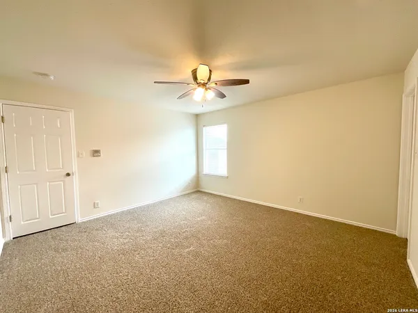 an empty room and a chandelier fan