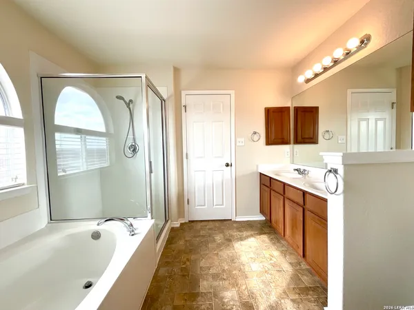 a spacious bathroom with a tub sink and mirror