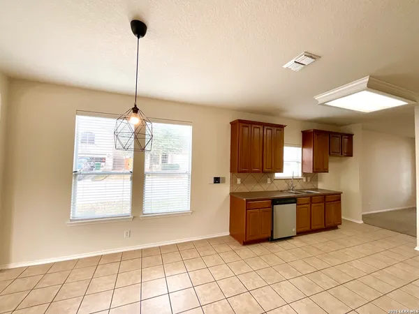 a kitchen with stainless steel appliances granite countertop a sink and a wooden floor
