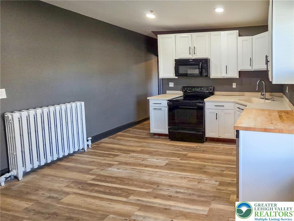 703 South Filmore Street Allentown, PA 18103 - Photo 5 of 15 a kitchen with wooden cabinets and stainless steel appliances