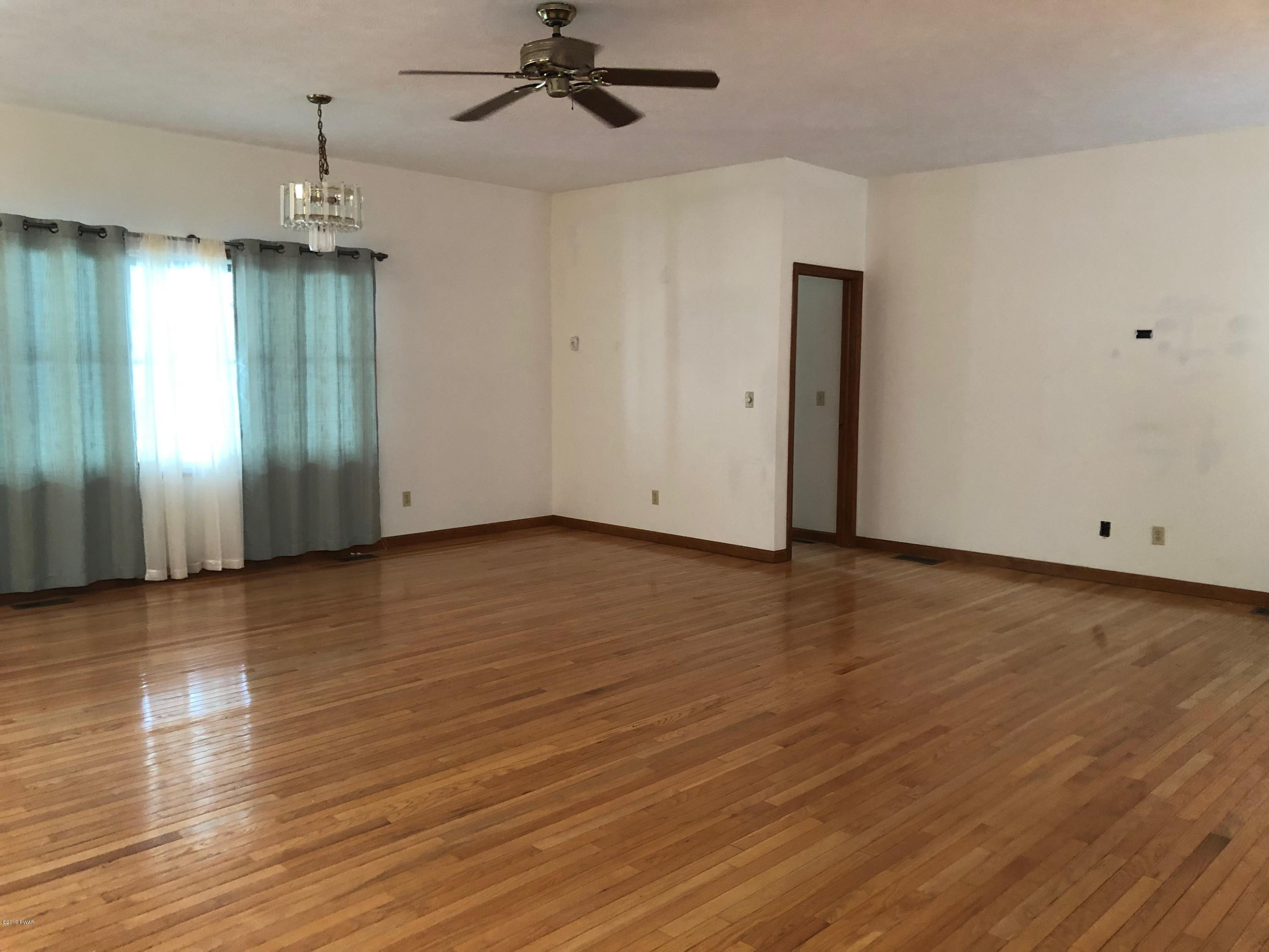 213 Maple Ridge Drive Hawley, PA 18428 - Photo 9 of 44 an empty room with wooden floor and windows