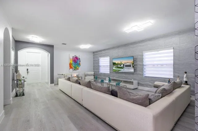 a living room with furniture and a wooden floor