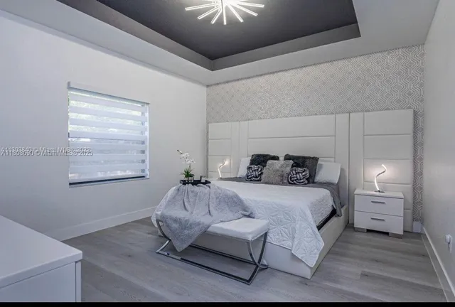 a bedroom with a bed and a chandelier