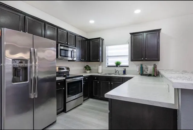 a kitchen with stainless steel appliances cabinets a sink and a refrigerator