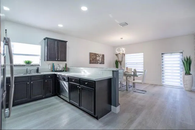 a kitchen with stainless steel appliances granite countertop a stove a sink dishwasher and a refrigerator