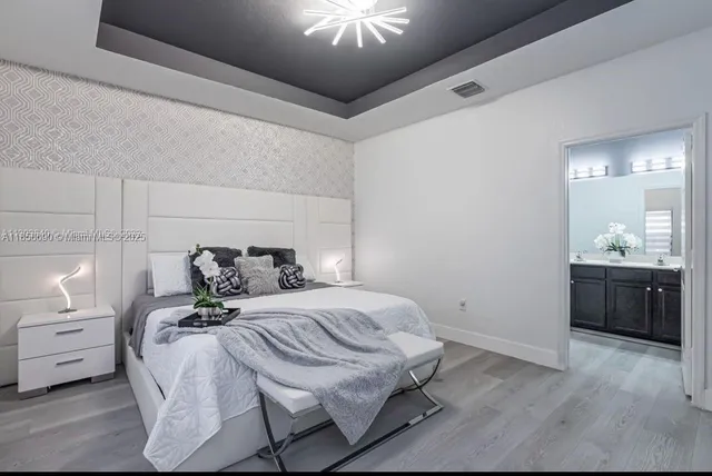 a bedroom with a bed and a chandelier