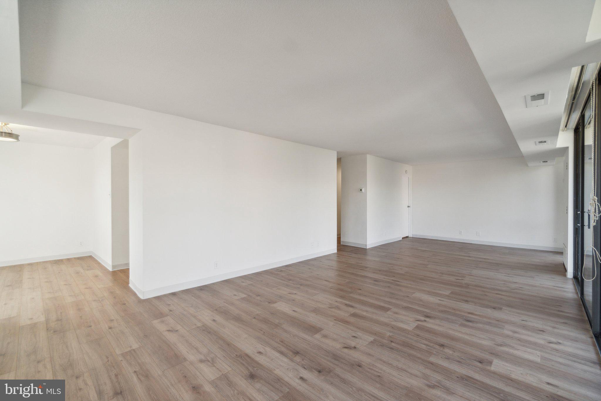 1401 North Rhodes Street, Unit 305 Arlington, VA 22209 - Photo 23 of 35 a view of an empty room with wooden floor