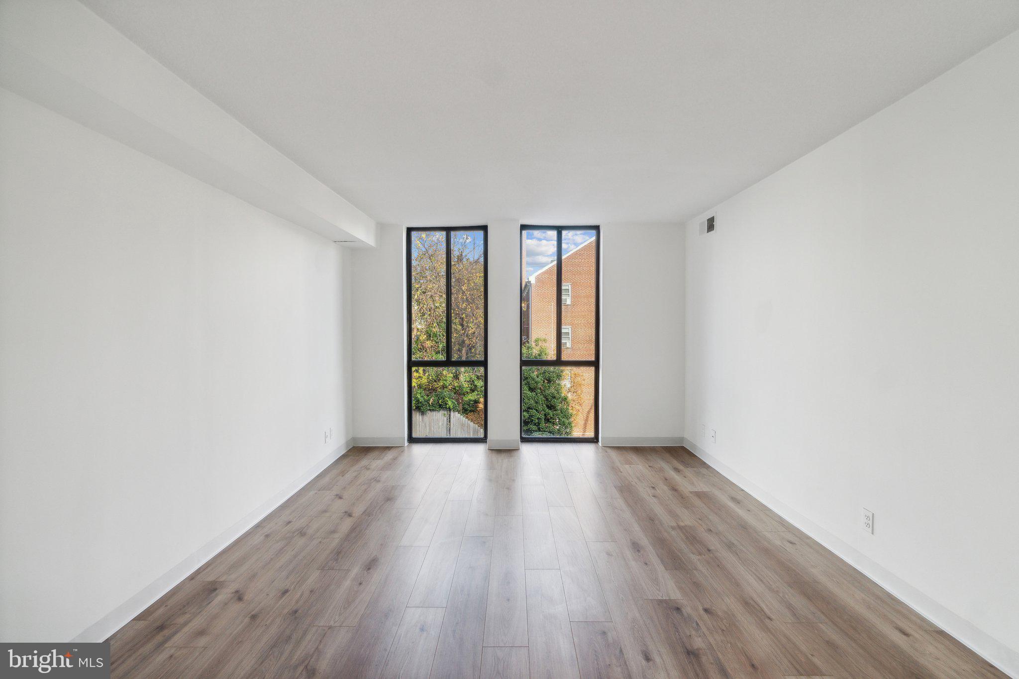 1401 North Rhodes Street, Unit 305 Arlington, VA 22209 - Photo 27 of 35 wooden floor in an empty room with a window