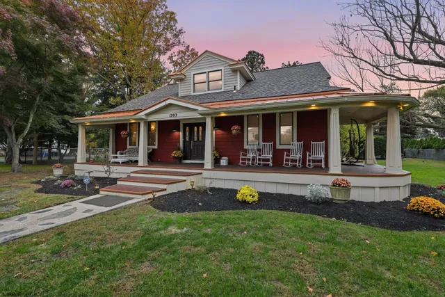 a view of a white house with a swimming pool and porch